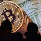 A Bitcoin logo in front of an American dollar with the silhouettes of people in front of it.